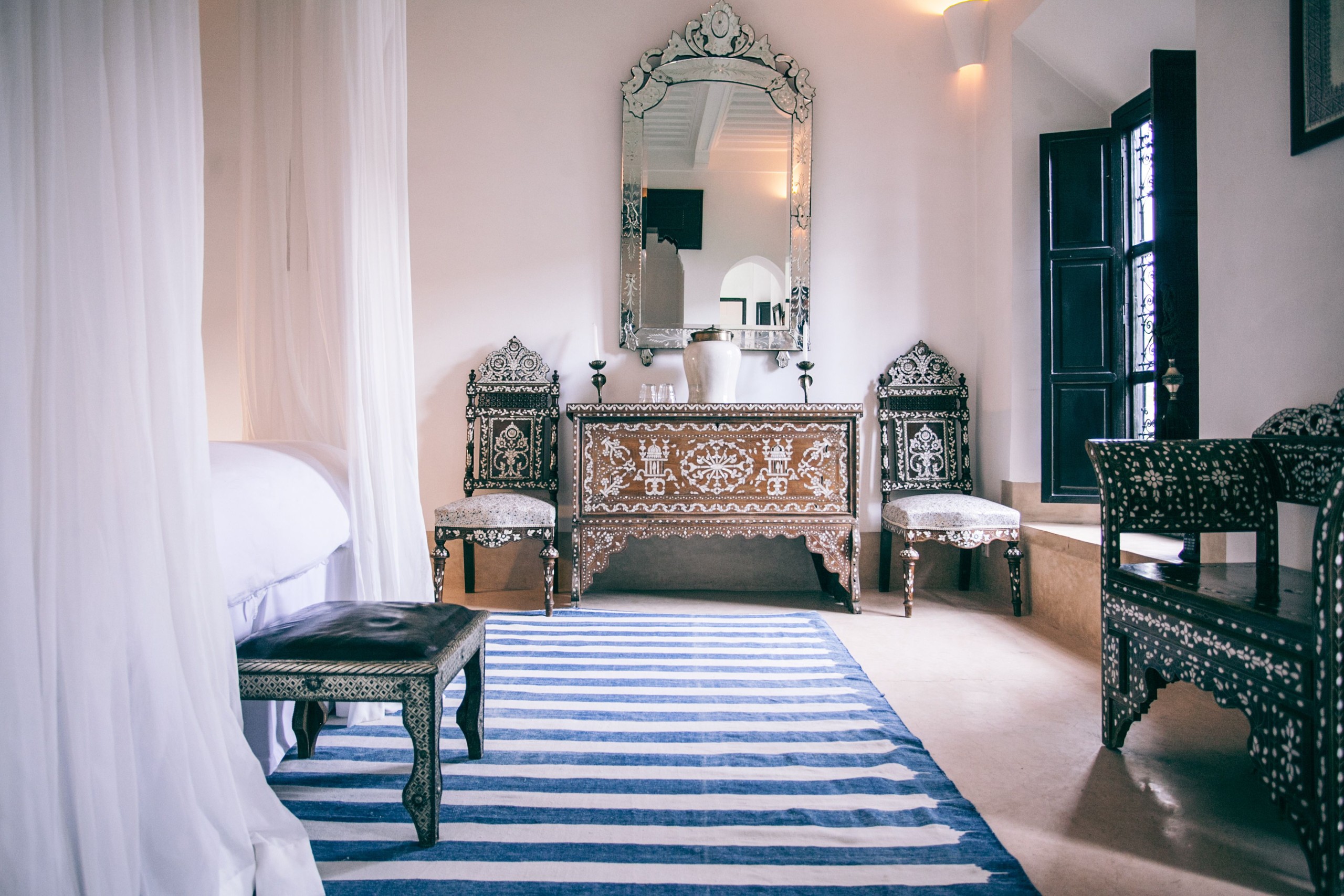 Chambre d’inspiration marocaine avec bois sculpté, textiles et lumière naturelle, référence pour une rénovation d’appartement à Marrakech