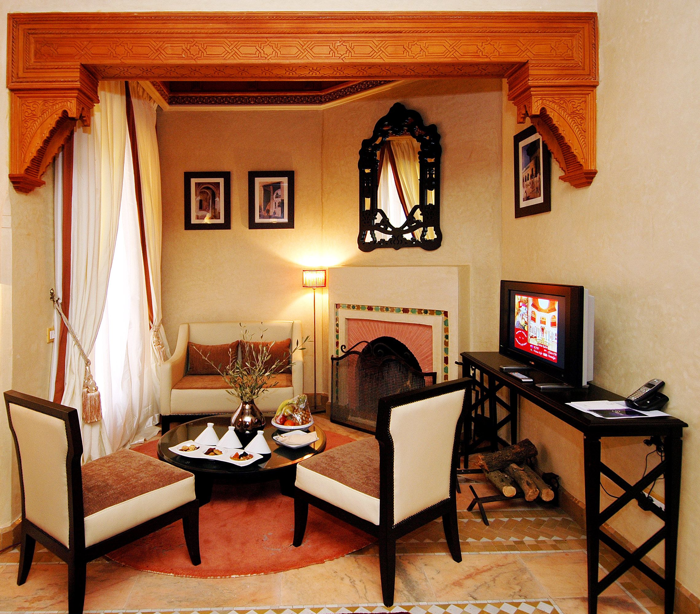 Salon marocain chaleureux avec éclairage, textures et assises confortables, référence éditoriale pour une rénovation d’appartement à Guéliz