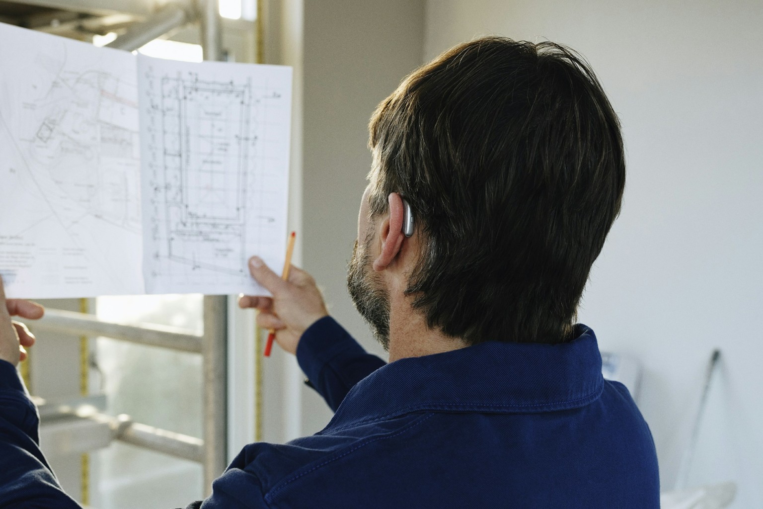 Architecte consultant les plans pendant le suivi d’un chantier